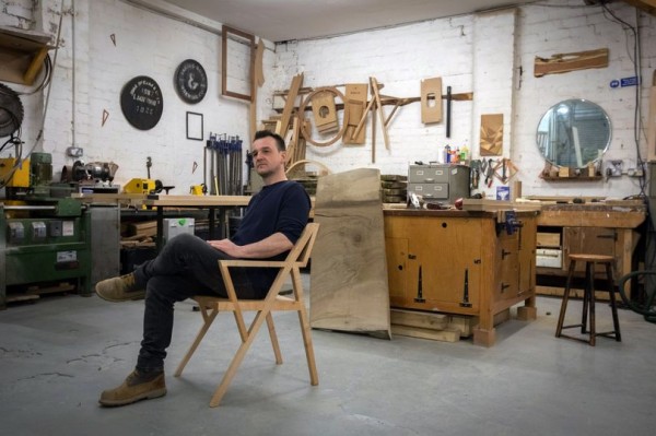 Furniture maker, Chris Turner sits in one of his chair creations